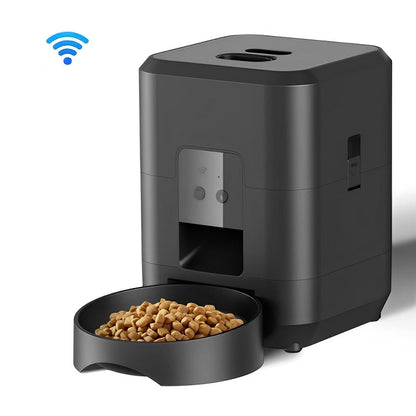Black pet feeder with a bowl of kibble and a smartphone displaying the app interface.